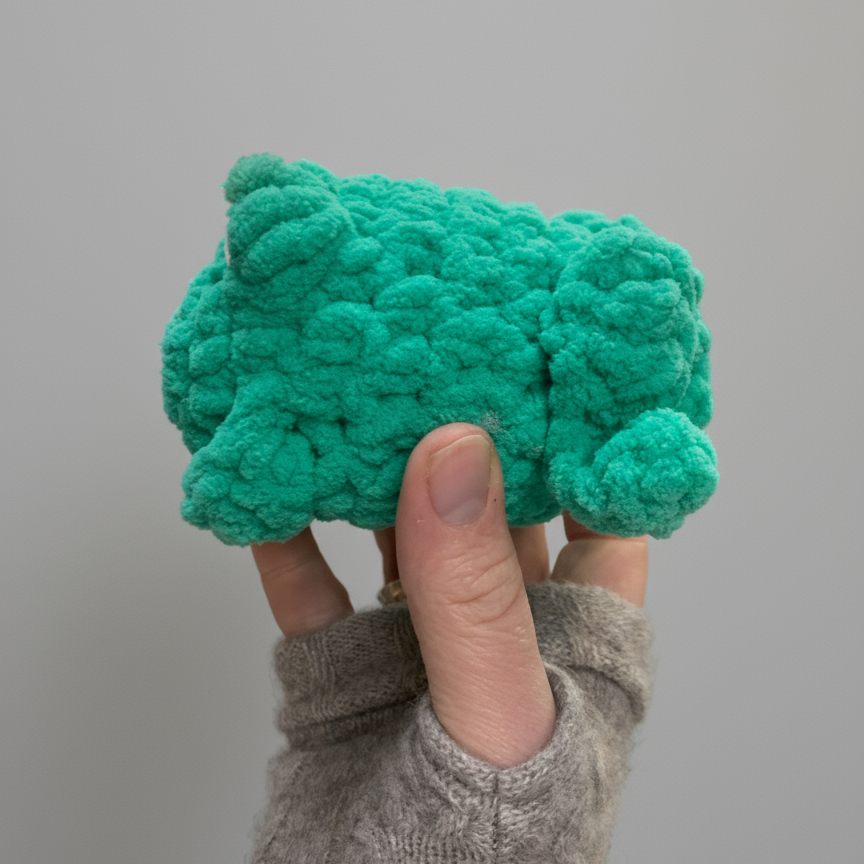 Handmade crocheted frog plush toy made with soft green blanket yarn and large safety eyes, approximately 4"x5"