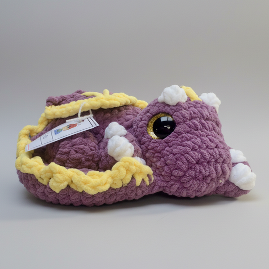 Handmade crocheted sleepy dragon plush made with soft plush blanket yarn and large safety eyes, approximately 14" wide and 4" high, perfect for cuddling or fantasy decor.
